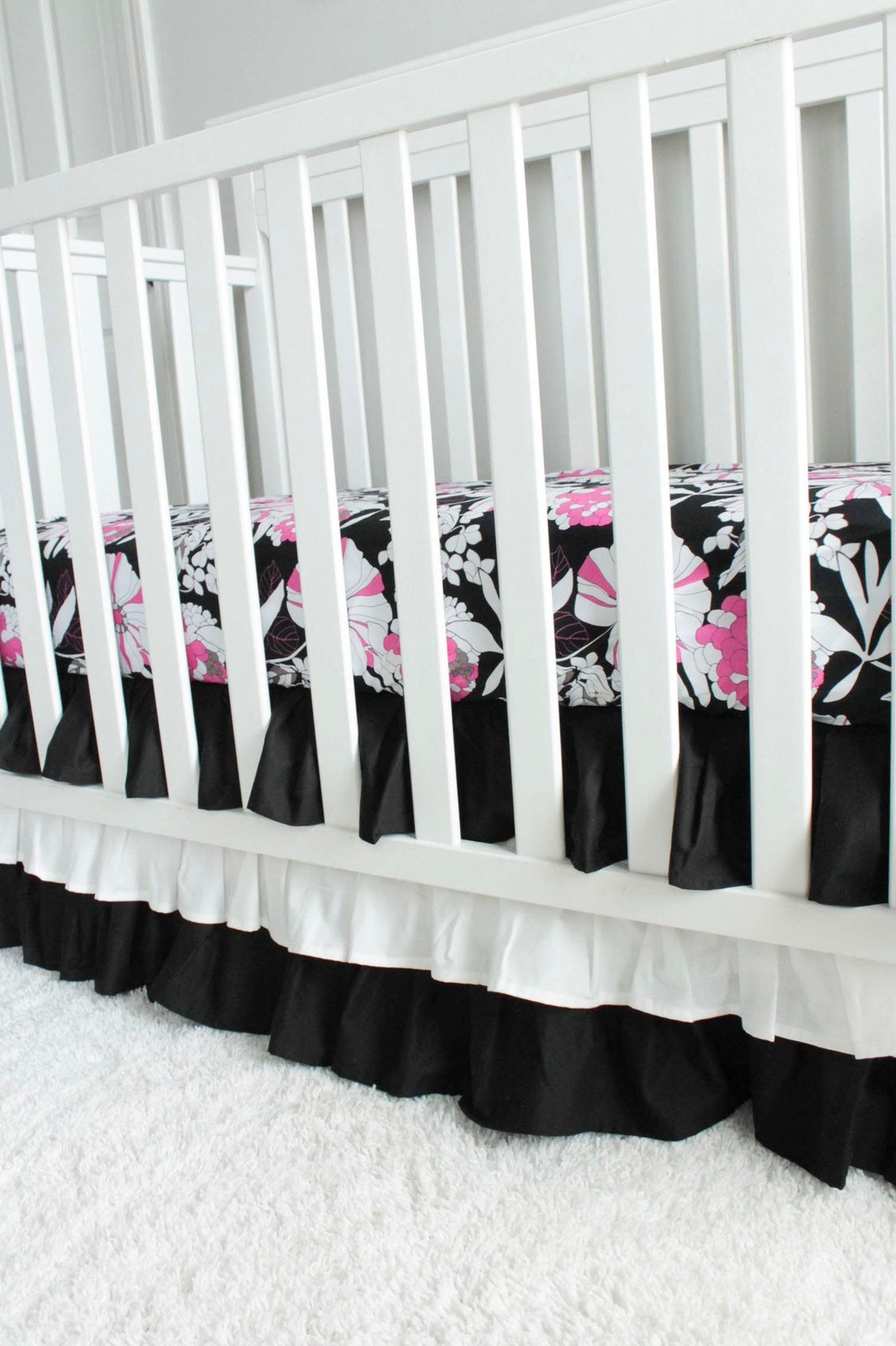 Black and white 3 tiered Crib Skirt. Pink and black floral crib sheet. Nursery bedding. In stock.