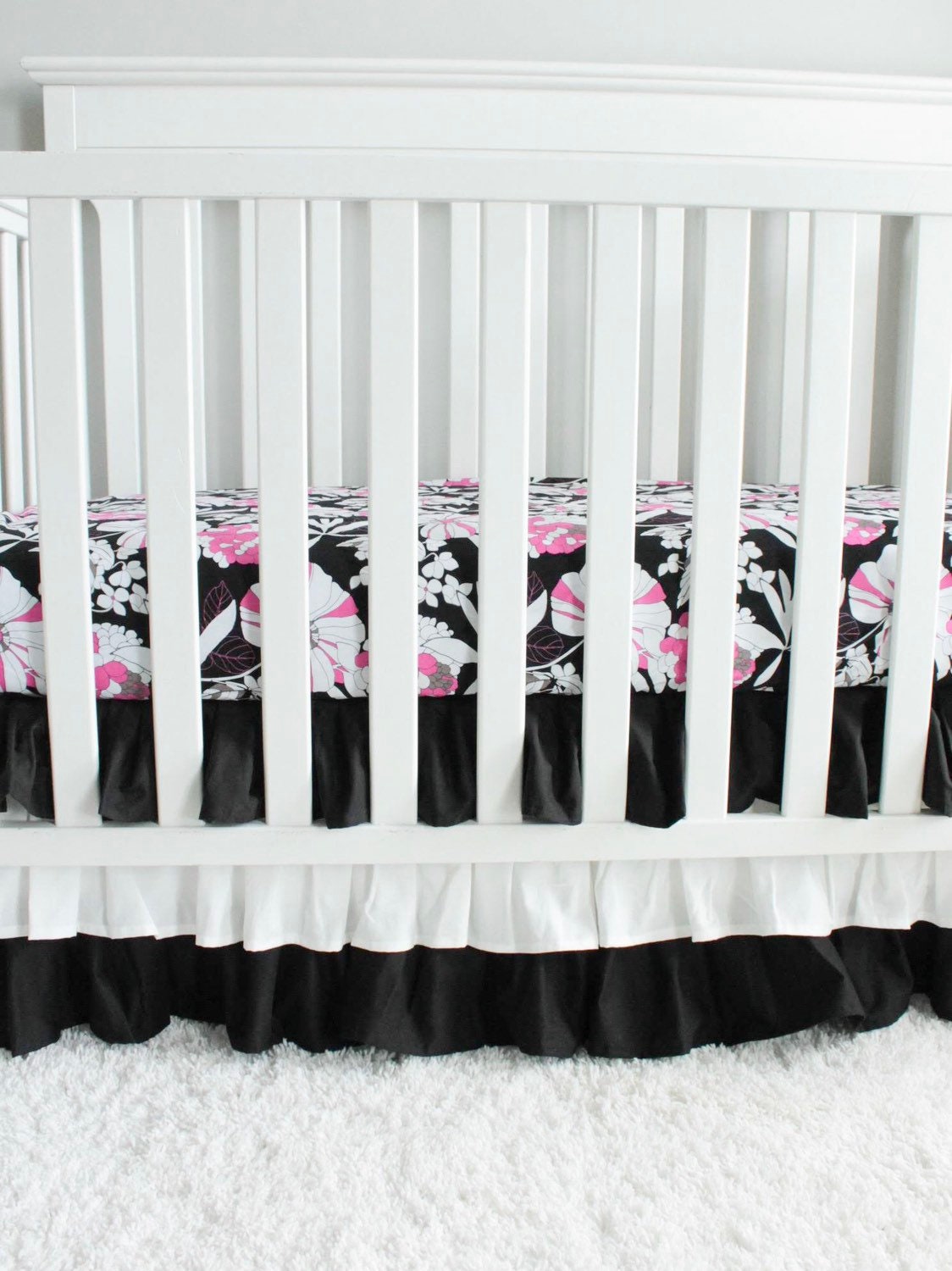 Black and white 3 tiered Crib Skirt. Pink and black floral crib sheet. Nursery bedding. In stock.