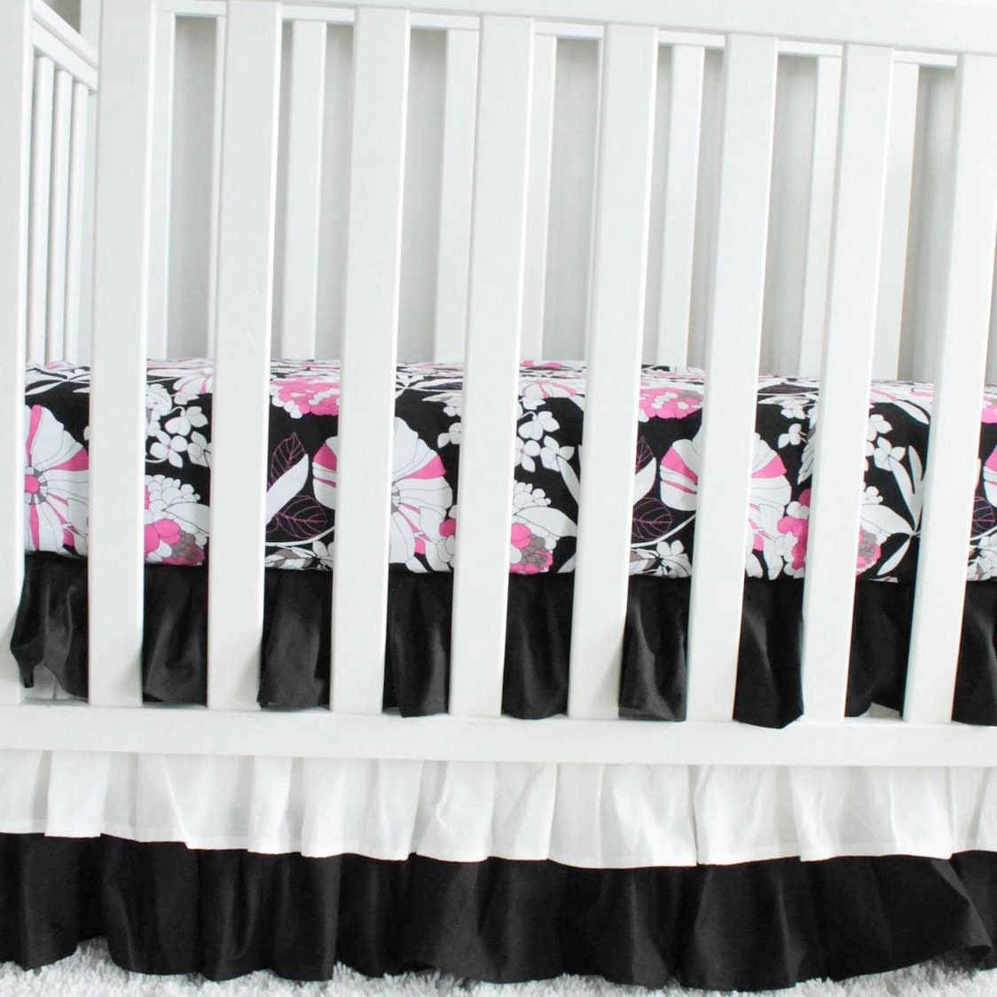 Black and white 3 tiered Crib Skirt. Pink and black floral crib sheet. Nursery bedding. In stock.